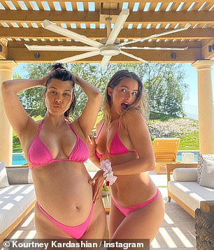 Pregnant Kourtney Kardashian flaunts her baby bump in a hot pink bikini as she reunites with BFF Addison Rae for sultry snaps by the pool