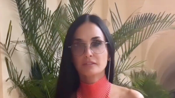 Demi Moore, 60, goes braless in teeny tiny red hot dress as she flirts with the camera during Milan Fashion Week