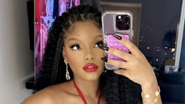 Halle Bailey covers her stomach in a loose red dress for new selfie and cuddles up to her ‘baby’ amid pregnancy rumors